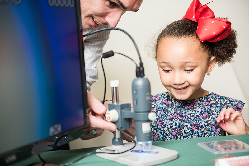 Teacher showing young girl science experiments